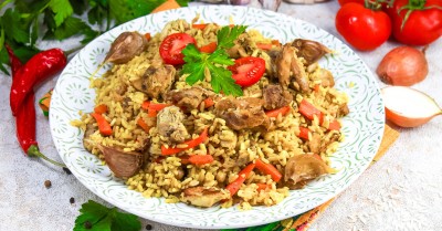 Рассыпчатый плов с курицей в кастрюле на плите