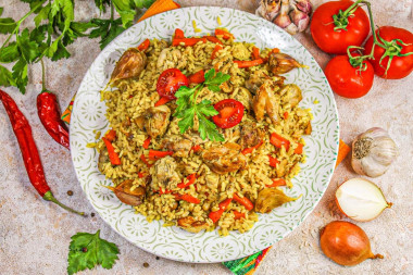 Рассыпчатый плов с курицей в кастрюле на плите Рассыпчатый плов с курицей в кастрюле на плите
