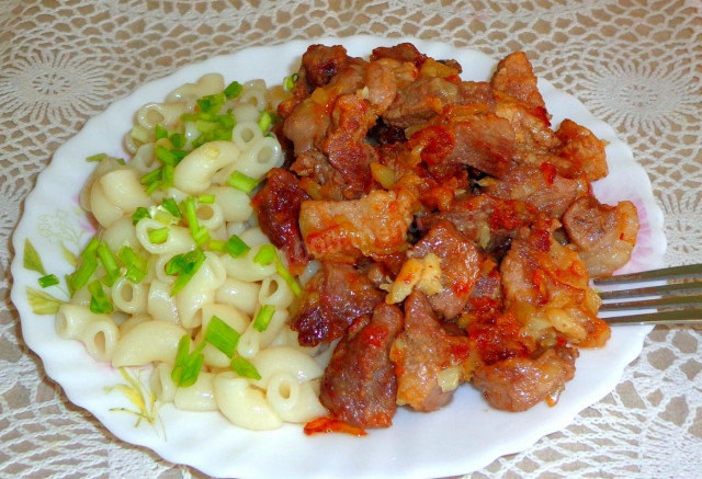 Жареные кусочки свинины на сковороде с луком