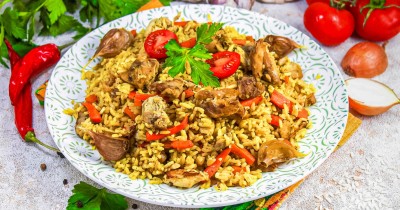 Рассыпчатый плов с курицей в кастрюле на плите