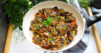 Вегетарианские жареные грибы с луком и морковью на сковороде