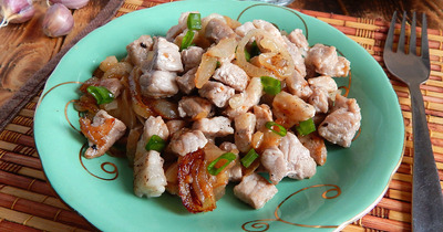 Мясо жареное с луком и чесноком на сковороде