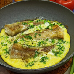 Рыба с яйцом и зелёным луком на сковороде