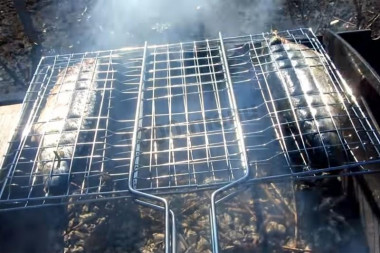 Рецепт - Скумбрия с чесночными стрелками на углях на решетке - Шаг 6 -  Угли к этому моменту должны прогореть. На горячие угли положите молодые веточки фруктовых деревьев (тут - вишня) для аромата копченого. Рыбу оботрите от маринада (внутри можно оставить лук), натрите растительным маслом и положите на решетку.