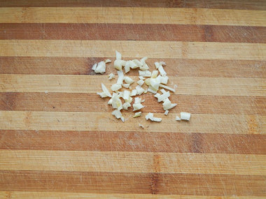 Рецепт - Салат из свеклы без варки с твердым сыром и грецким орехом - Шаг 3 -  Известно, что сырая свекла имеет небольшую специфическую горчинку во вкусе, которая не всем нравится, поэтому лучше добавить в салат пару зубчиков чеснока и свежую зелень, они отлично оттенят вкус. Зубчики чеснока очищаем от шелухи, мелко рубим их ножом, натираем на терке или пропускаем через пресс.