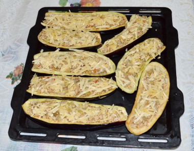 Рецепт - Мясные лодочки из баклажанов с болгарским перцем и сыром - Шаг 9 -  Баклажанные лодочки промываем, стряхиваем с них воду. Наполняем лодочки начинкой, сверху посыпаем тертым сыром и выкладываем на противень. Запекаем в духовке 30 минут при температуре 180 градусов: сначала 25 мин. на нижней полке, затем - 5 мин. на верхней, чтобы зарумянился сыр. Готовность блюда проверяем, протыкая вилкой лодочки, - если вилка входит легко, то они готовы.