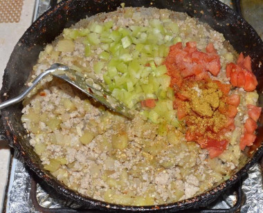 Рецепт - Мясные лодочки из баклажанов с болгарским перцем и сыром - Шаг 8 -  Теперь добавляем помидоры и перец. Также не забываем про соль и любимые специи. Все тщательно перемешиваем, обжариваем еще 8-10 минут и снимаем сковороду с плиты.