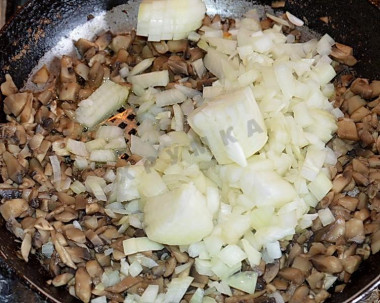 Рецепт - Салат с куриным филе, ананасами, грибами и сыром - Шаг 3 -  На сухую раскалённую сковороду высыпаем измельчённые грибы, периодически помешиваем до тех пор, пока из них выделяется влага. Затем наливаем растительное масло и добавляем нарезанный лук.