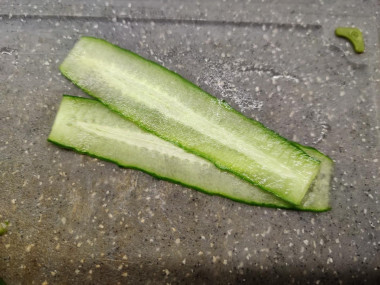 Рецепт - Салат с вареной колбасой и сыром - Шаг 2 -  Если есть желание перед подачей украсить салат огуречными завитками, то их нужно заранее заготовить. Просто срежьте с огурцов несколько слайсов с помощью овощечистки до того, как начать их шинковать. Этот шаг необязателен.