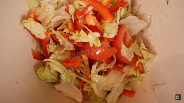 Рецепт - Мясной рулет с моцареллой и овощами - Шаг 5 -  6. Пока наш рулет находится в духовке, приготовим салат. Нарезаем  помидор и перец, добавляем к ним салат Айсберг и кунжутное масло.