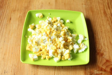 Рецепт - Рыбный салат с сайрой луком рисом майонезом - Шаг 4 -  Яйца отварим, очистим от скорлупы и мелко нарежем кубиками.