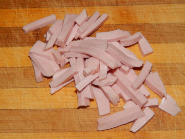 Рецепт - Салат коктейль с вареной колбасой помидором огурцом сыром - Шаг 2 -  Вареную колбасу нарезаем тонкой соломкой.Выкладываем ее первым слоем в бокал, смазываем майонезом.