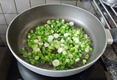 Рецепт - Помидоры тушеные с томатной пастой - Шаг 7 -  В хорошо разогретую сковороду кладем сливочное масло и зеленый лук, слегка обжариваем в течение 1 минуты.