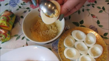 Рецепт - Салат Сугробы смаонезом, ветчиной и сыром - Шаг 4 -  Варёные яйца разрезать пополам и вынуть желтки. Желтки размять вилкой, немного посолить, добавить 2 ложки майонеза и выдавить чеснок. Всю массу тщательно перемешать и нафаршировать белки. Половинки яиц выложить сверху колбасы белком вверх, образовывая холмики.