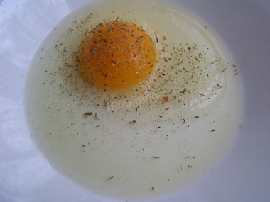 Рецепт - Филе трески в яичном кляре на молоке жареное с луком - Шаг 3 -  Рыба пусть слегка подмаринуется, а теперь надо сделать кляр. Работа начинается с яиц. В тарелку вбивается яйцо. Можно прямо сейчас посыпать его специями.