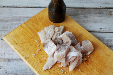 Рецепт - Пирог с картошкой рыбой на крахмальном тесте без дрожжей - Шаг 3 -  Филе можно оставить целиком, а можно порезать на кусочки. Рыбу посолите, поперчите, можете сбрызнуть подсолнечным маслом. Пусть полежит, пока займетесь подготовкой остальных ингредиентов.