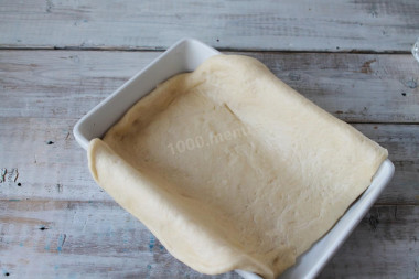 Рецепт - Пирог с картошкой рыбой на крахмальном тесте без дрожжей - Шаг 8 -  Тесто подошло, подбейте его, дайте подойти еще раз. Раскатайте его в пласт размером, превышающим форму для выпечки вдвое. Форму смажьте подсолнечным маслом и выложите на нее пласт теста так, чтобы края его свисали поверх формы.