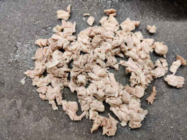 Рецепт - Салат с куриными бедрышками, ананасом и грецкими орехами - Шаг 2 -  Куриные бёдрышки предварительно отварить до готовности в подсоленной воде и остудить, чтобы было комфортно рукам. Нашинковать куриное мясо мелким кубиком.