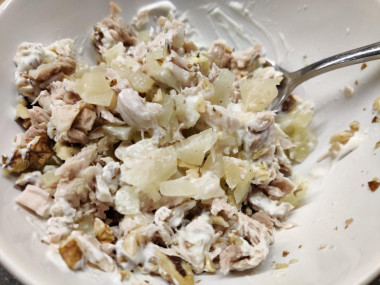 Рецепт - Салат с куриными бедрышками, ананасом и грецкими орехами - Шаг 5 -  В отдельной миске смешать ананасы, куриное мясо и грецкие орехи. Приправить солью по вкусу. И заправить майонезом. Сюда идеально подойдёт домашний майонез или обычный провансаль. Салат выложить в блюдо для подачи и украсить свежей зеленью, грецкими орехами и кусочками ананаса.