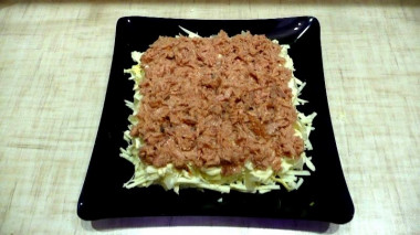 Рецепт - Салат Хризантема с плавленым сыром тунцом и яблоками - Шаг 9 -  Рыбную консерву размять вилкой и выложить в салатник. Формируем четвертый слой и смазываем майонезом