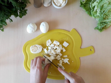 Рецепт - Салат с пекинской капустой палочками огурцами яйцом - Шаг 4 -  Мелко нарежьте отваренные вкрутую куриные яйца и добавьте их к огурцам с кукурузой и крабовыми палочками.