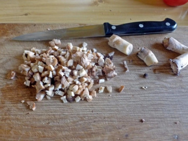 Рецепт - Грибы с сыром томатами в духовке - Шаг 3 -  Ножки шампиньонов нарезаем мелкими кубиками.