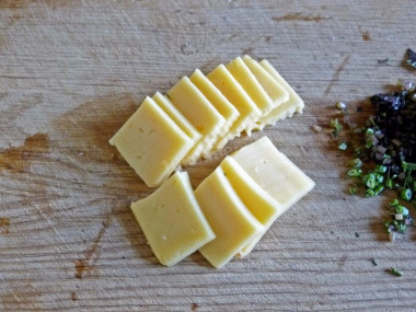 Рецепт - Грибы с сыром томатами в духовке - Шаг 8 -  Вторую половину сыра нарезаем пластинками.