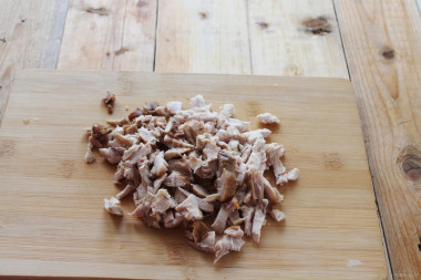 Рецепт - Курино-грибной жульен в духовке со сливками - Шаг 2 -  Разогрейте в сковороде растительное масло с высокой температурой дымления. Обжарьте на среднем огне мелко нарезанный лук до прозрачности. Добавьте к нему шампиньоны и жарьте, помешивая, до румяности (примерно 5-7 минут, пока жидкость не выпарится). Теперь к грибам и луку отправьте мелко нарезанную курицу и обжарьте ее до румяной корочки (примерно 1-2 минуты), не забывая помешивать. Не берите суховатую куриную грудку. С бедрышками блюдо будет более сочным.