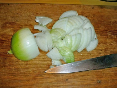 Рецепт - Салат Восторг с жареными грибами без орехов и чернослива - Шаг 4 -  Очищенный репчатый лук нарежьте тонкими четвертькольцами.