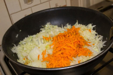 Рецепт - Ржаные пирожки с капустой и сырокопченой колбасой - Шаг 4 -  Выкладываем лук с морковью к капусте, перемешиваем, убавляем огонь до минимума и оставляем тушиться