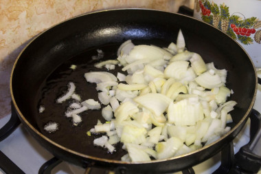 Рецепт - Грибной куриный жюльен с чесноком - Шаг 6 -  Лук пассеруем на растительном масле до прозрачности, здесь золотистый цвет нам не нужен - готовое блюдо будет горчить. Добавьте к луку измельченный чеснок.
