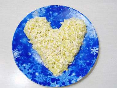 Рецепт - Салат с курицей и картошкой Крыска - Шаг 5 -  На тарелке, при помощи корнетика, рисуем контур мордочки крыски.Теперь по контуру распределяем наш тертый картофель и наносим сверху сеточку из майонеза.