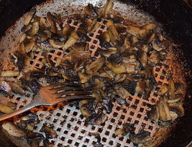 Рецепт - Салат Мужские слёзы с гранатом - Шаг 3 -  На раскалённой сковороде обжариваем на растительном масле до лёгкого румянца порезанные пластинками шампиньоны, солим и перчим их по вкусу.