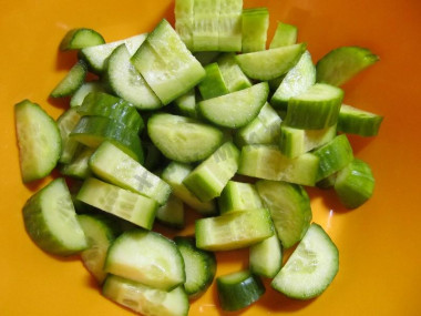 Рецепт - Салат маслины фетакса помидоры огурцы лук перец - Шаг 2 -  Разрежьте огурцы пополам. Каждую половинку нарежьте полумесяцем.