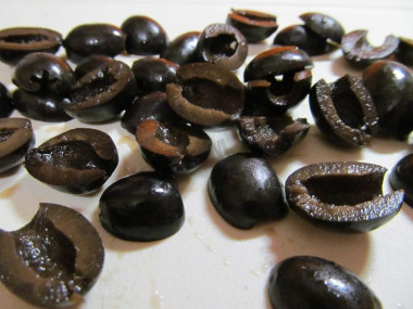 Рецепт - Салат маслины фетакса помидоры огурцы лук перец - Шаг 3 -  Маслины разрежьте на две половинки. Как правильно выбирать маслины? Лучше покупать продукт в прозрачной упаковке. Так вы сможете рассмотреть их внешний вид и цвет. Если маслины слишком черные, значит добавлены пищевые красители. Плоды должны быть упругими, целыми, с гладкой, блестящей кожицей. Слишком мягкие, перезрелые маслины долго храниться не будут.