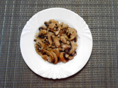 Рецепт - Салат Восторг с малосольным огурцом - Шаг 7 -  Обжариваем грибы и лук на подсолнечном масле с солью и выкладываем на блюдо, как первый слой салата. Смазываем майонезом.