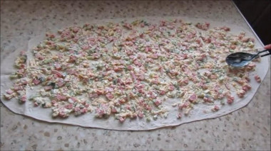 Рецепт - Рулет из лаваша с копченой колбасой и сыром - Шаг 2 -  Все ингредиенты для начинки лаваша поместить в глубокую миску, совсем чуть-чуть посолить, помня, что почти все ингредиенты уже соленые, заправить майонезом и перемешать до однородного состояния. Лаваш разложить на чистой, гладкой поверхности и равномерно распределить по нему начинку.