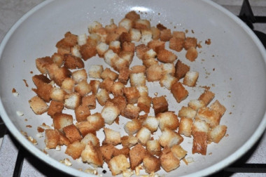 Рецепт - Салат Цезарь с перепелиным яйцом и пекинской капустой - Шаг 7 -  Белый батон режем кубиками и запекаем их в духовке до румяного состояния. Готовые крутоны обжариваем немного в масле с измельченным чесноком. Масла наливаем совсем немного, чтобы они не стали слишком масляными.