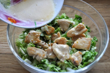 Рецепт - Салат Цезарь с перепелиным яйцом и пекинской капустой - Шаг 8 -  Нарезанную пекинскую капусту перекладываем в миску, добавляем к ней обжаренное куриное филе и заливаем соусом. Все перемешиваем.