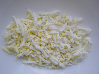 Рецепт - Салат с крабовыми палочками, луком, зеленью и майонезом - Шаг 4 -  Яйца остыли? Давайте очистим их и натрем крупно.