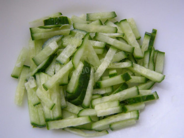 Рецепт - Салат с крабовыми палочками, луком, зеленью и майонезом - Шаг 5 -  А вот тут подошел и черед огурчика свежего. Мелкой соломкой накромсаем. Но так чтобы огурчик был виден.