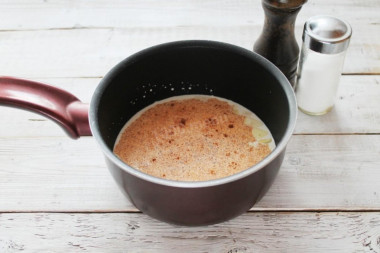 Рецепт - Картофельный гратен в духовке классический - Шаг 3 -  Сливки вылейте в сотейник, посолите, поперчите, добавьте мускатный орех и дольки чеснока. Доведите смесь до кипения.