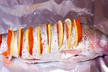 Рецепт - Судак с луком и морской солью - Шаг 9 -  Просоленный и обмазанный маринадом судак кладется на фольгу, смазанную маслом. В надрезы вкладывается долька лимона и колечко томата.