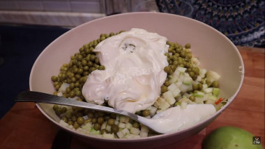 Рецепт - Оливье с копченым окороком и зеленым яблоком - Шаг 4 -  4. Изумительный вкус нам придаст обычное зелёное яблоко. Нарезаем  ,как и остальные ингредиенты. Высыпаем горошек и добавляем майонез. Завершающим штрихом  добавим оливкового масла . Солим и перчим по вкусу. Все тщательно перемешаем.
