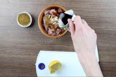 Рецепт - Салат Цезарь соусом с анчоусами - Шаг 3 -  К филе добавьте чеснок, сок лимона (1 ст.л. примерно), специи для курицы и залейте все соевым соусом.