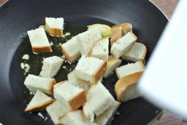 Рецепт - Салат Цезарь соусом с анчоусами - Шаг 7 -  Выложите в масло батонные кусочки и обжарьте.