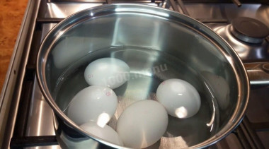 Рецепт - Салат Чайка с сыром, яйцами и горошком - Шаг 1 - Куриные яйца отварите вкрутую: помойте их, переложите в кастрюльку, залейте водой, поставьте на плиту и после закипания воды варите яйца в течение 10 минут.Затем яйца переложите в холодную воду и остудите.Остывшие яйца очистите от скорлупы.