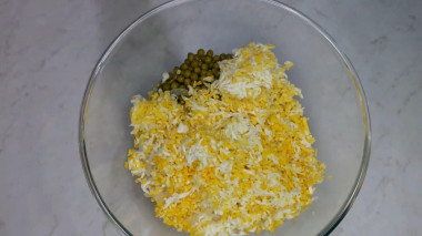 Рецепт - Салат Чайка с сыром, яйцами и горошком - Шаг 9 -  Слейте жидкость с консервированного горошка, откиньте горошек на сито, ополосните проточной водой.Поместите все подготовленные ингредиенты в салатник.