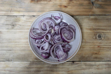 Рецепт - Салат из консервированной фасоли с филе курицы и сыром - Шаг 3 -  Репчатый лук чистим от шелухи и нарезаем четвертинками колец или кубиками. Если лук используется не салатного сорта, то его лучше замариновать в яблочном уксусе, чтобы он стал менее горьким. Для этого нарезанный лук кладем в тарелочку, заливаем уксусом и добавляем сахар, оставляем на 10 минут, жидкость сливаем.