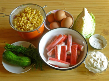 Рецепт - Крабовый салат без риса с молодой капустой - Шаг 1 - Сначала подготовим все продукты, указанные в списке. Яйца отварим вкрутую, крабовые палочки, если замороженные, разморозим, консервированную кукурузу откинем на дуршлаг. Овощи – огурец, капусту, а также зелень – моем.